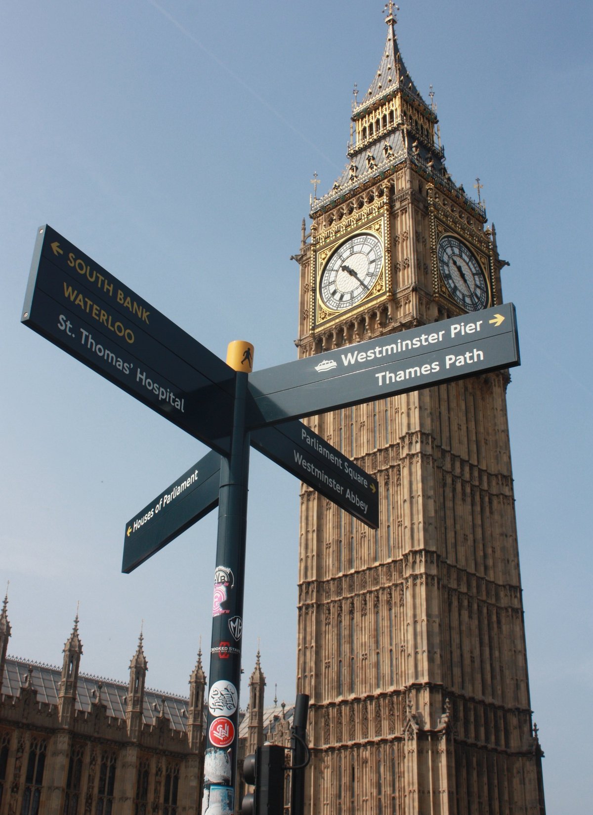A sign post next to Westminster Bridge with the Elizabeth Tower in the background.