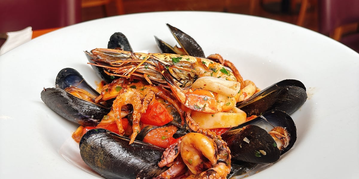 Linguine di Mare: Fresh squid ink black pasta, clams, mussels, octopus, calamari, tomato, chilli, parsley, wine and king prawn