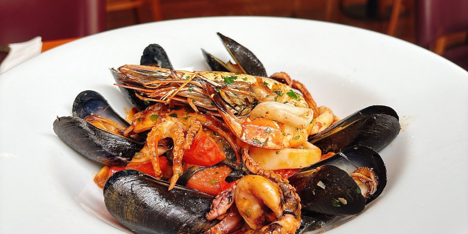 Linguine di Mare: Fresh squid ink black pasta, clams, mussels, octopus, calamari, tomato, chilli, parsley, wine and king prawn